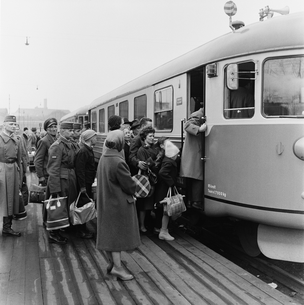 Matkustajia nousemassa kiskobussiin eli lättähattuun Rautatieasemalla.