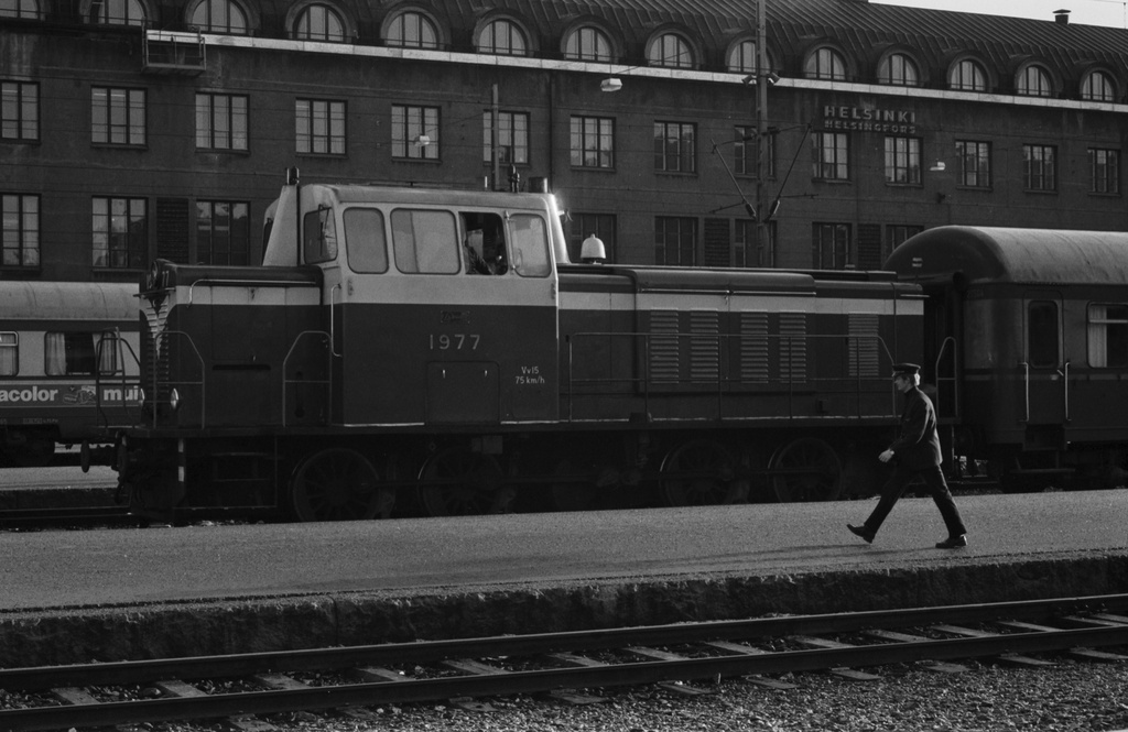 Helsingin rautatieasema. Junia Helsingin rautatieasemalla. Keskellä Vv15-sarjan dieselveturi 1977.