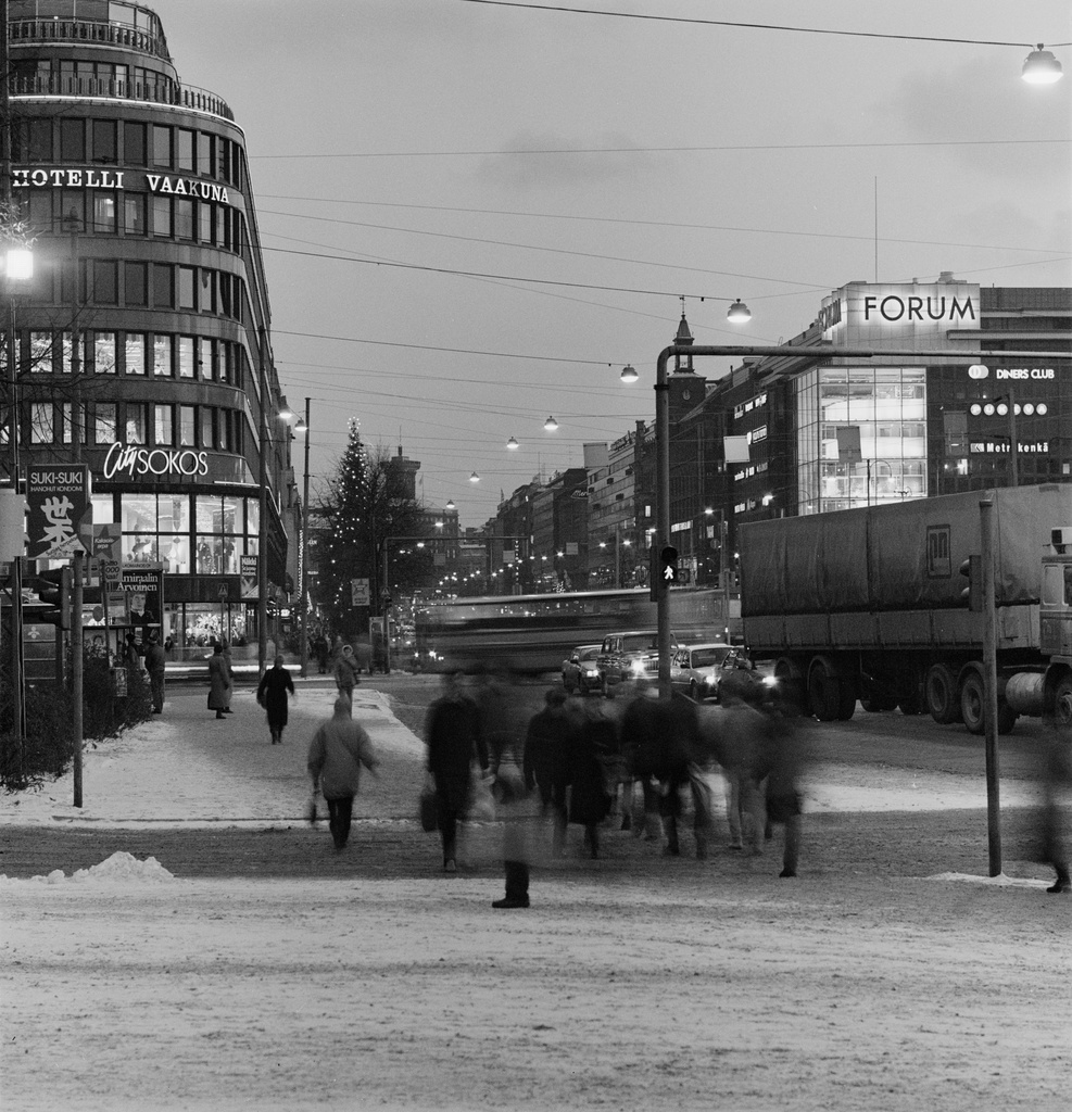 Jalankulkijoita ja liikennettä Mannerheimintiellä Postitalon kohdalla (= Mannerheiminaukiolla). Vasemmalla Sokos, oikealla Forum.