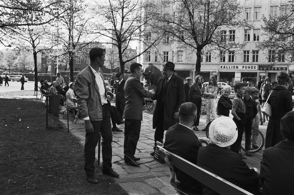 Karhupuisto. Uskonnollista sanomaa julistavat nainen ja mies ihmisten keskellä Karhupuiston laidalla.