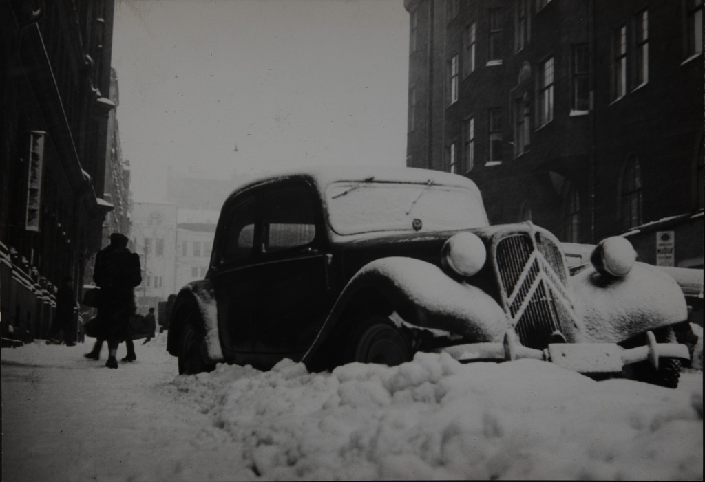 Auto lumessa Etelä-Makasiininkadulla (= Eteläinen Makasiinikatu). Auto aikanaan edistyksellinen Citroen Traction Avant.