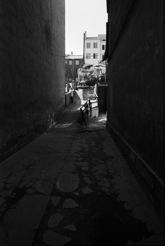 Fleminginkatu 16. Näkymä pihalle Fleminginkatu 14 ja 16 välisestä avoimesta porttikongista. Taustalla häämöttää Fleminginkatu 16 pihalla oleva korkea kallio.