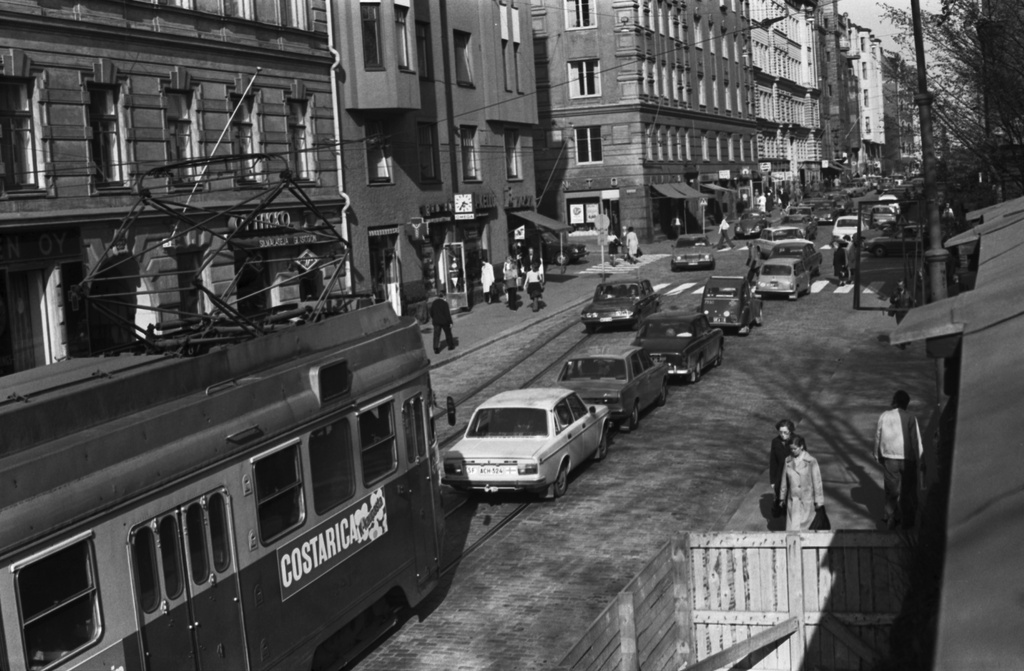 Liisankatu. Iltapäivän ruuhkaliikennettä Liisankadulla Kaisaniemen puoleisessa päässä. Kevääseen 1975 mennessä Liisankatu oli muuttunut läpiajokaduksi. Näkymä kiviaidan päältä itään Snellmaninkadun suuntaan.
