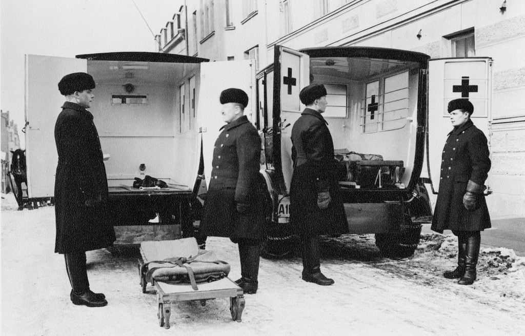 Ambulanssiautoja kadulla 1920-luvun alussa Helsingissä, Vironkatu 1:n edessä, vasemmalla palomies Kalle Seppälä.