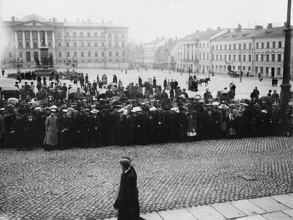 Keisarillisen Aleksanterin yliopiston (Helsingin yliopisto) promootio 1907. Yleisöä Senaatintorilla yliopiston edessä. Taustalla vasemmalla Keisari Aleksanteri II:n muistopatsas.
