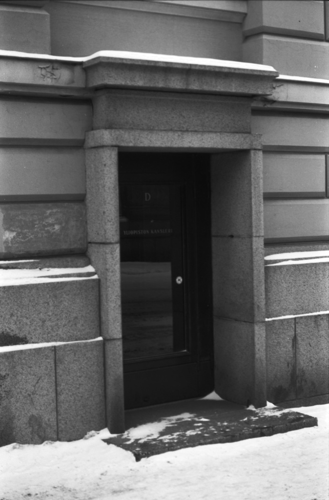 Yliopistonkatu 2. Ulko-ovi, jossa teksti Yliopiston kansleri Helsingin yliopiston päärakennuksessa.