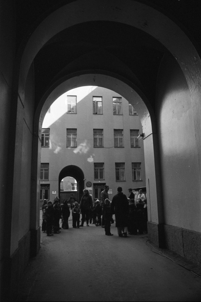 Vironkatu 7. Vironniemen päiväkodin lapsia opettajineen Vironkatu 7:n pihalla ja porttikäytävässä. Tutustumiskäynti porrashuoneremonttiin on ohi ja vuorossa on paluu päiväkotiin.