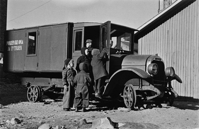 Elannon päiväkodin lapsia leikkimässä Viides linja 4:n pihalla olevan vanhan auton luona. Auto on käytöstä poistettu leipäauto ja siitä on tehty lasten leikkipaikka. Sen kyljessä lukee "poikien ikioma ja tyttöjen".  similar photo