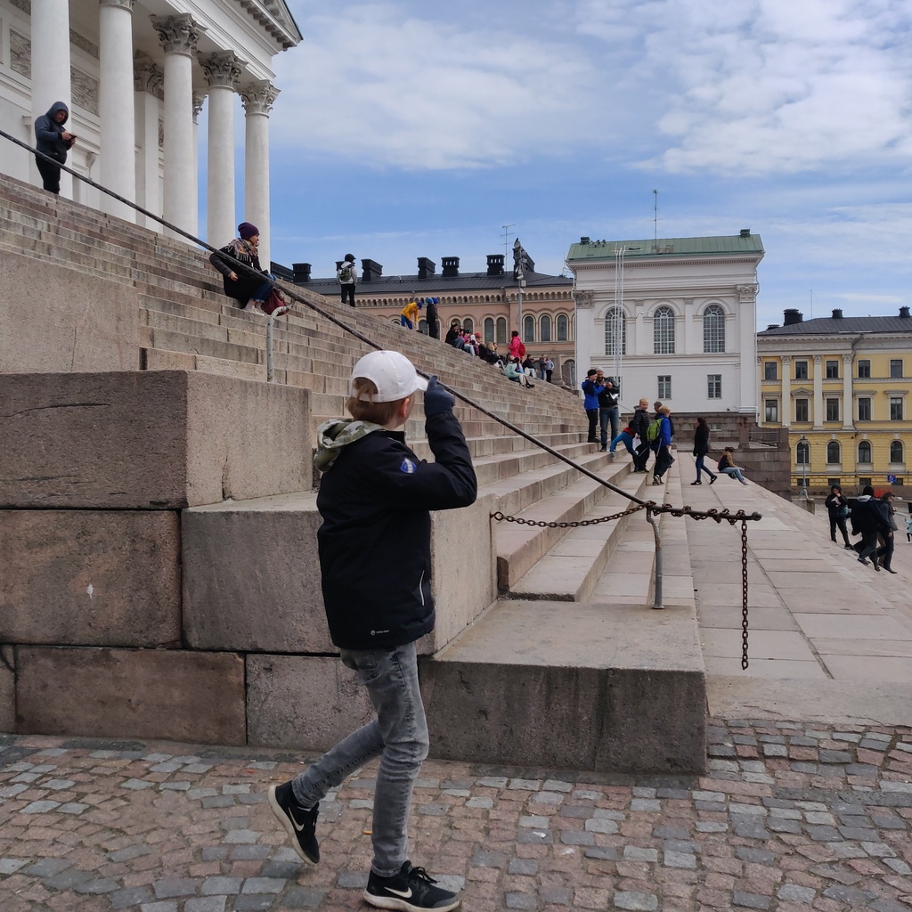 Kaupunkilaisia istumassa Tuomiokirkon portailla. rephoto