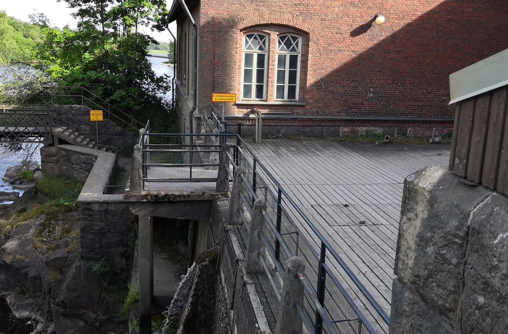 Ihmisiä Vanhankaupunginkoskella jäidenlähdön aikaan. Yksi mies maalaamassa. rephoto