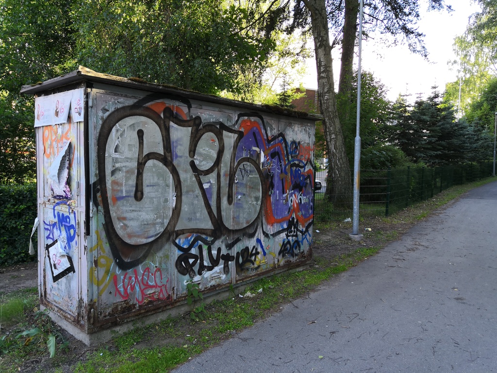 Graffitien ja mainosjulisteiden värikkäästi peittämä sähkökaappi rephoto