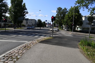 Malmi Ylä-Malmi. Syksyinen näkymä auton ikkunasta Kirkonkyläntielle. Oikella talo, jossa ravintola Malmi Kesti, vasemmalla asuinkerrostalo ja liikerakennus, jossa mm. Malmin kirjakauppa. Kadulla pysäköityjä autoja, mm. Skoda Octavia, Simca 1000 ja Triumph Herald. rephoto