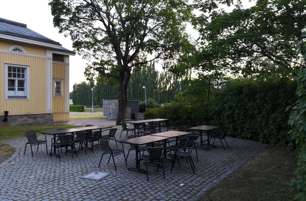 Viikinkaari 8. Näkymä Viikin Latokartanosta vanhan puutalon pihapiiristä. Taustalla pilkottaa Viikin Unionin huoltoasema sekä tienviitat Keskustaan, Lahteen ja Malmille. rephoto