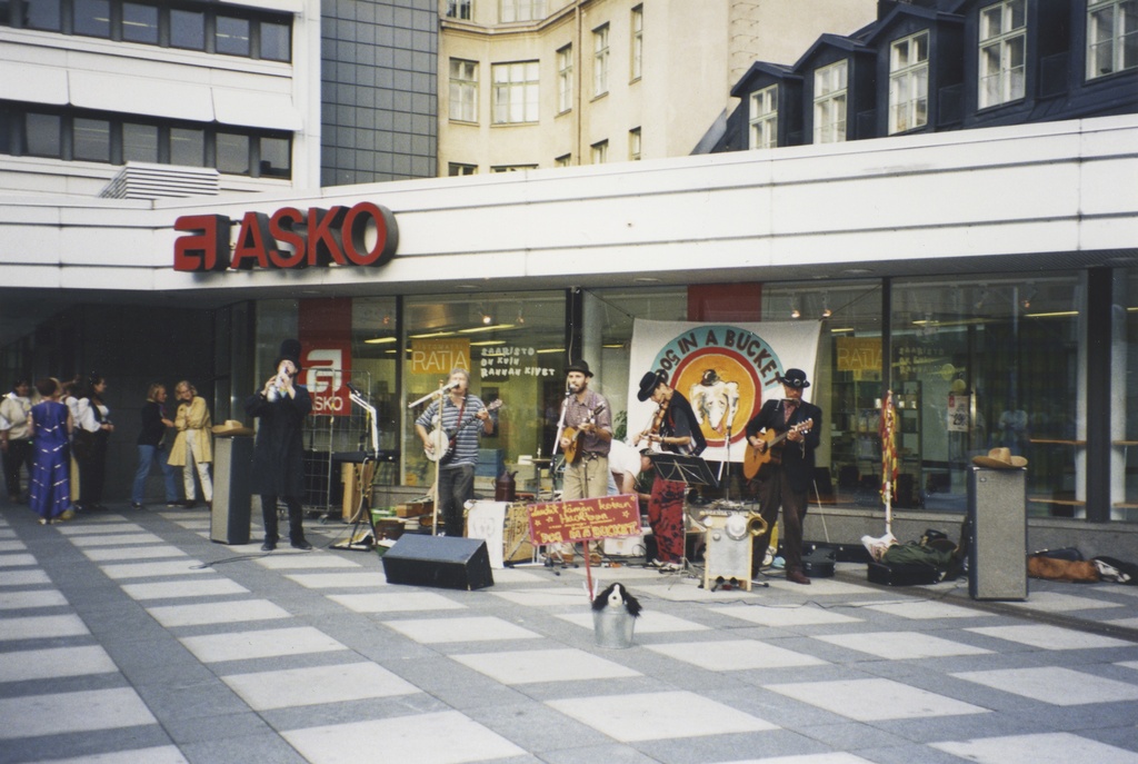 Dog In A Bucket -yhtye esiintyy kauppakeskus Forumin Kukontorilla. Yhtye esittää jug band -tyylistä musiikkia. Edustalla yhtyeen maskottikoira peltiämpärissä. Taustalla yhtyeen esiintymistä seuraavaa yleisöä.