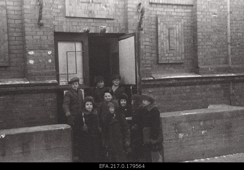 VII the front of the primary school. Students are leaving.