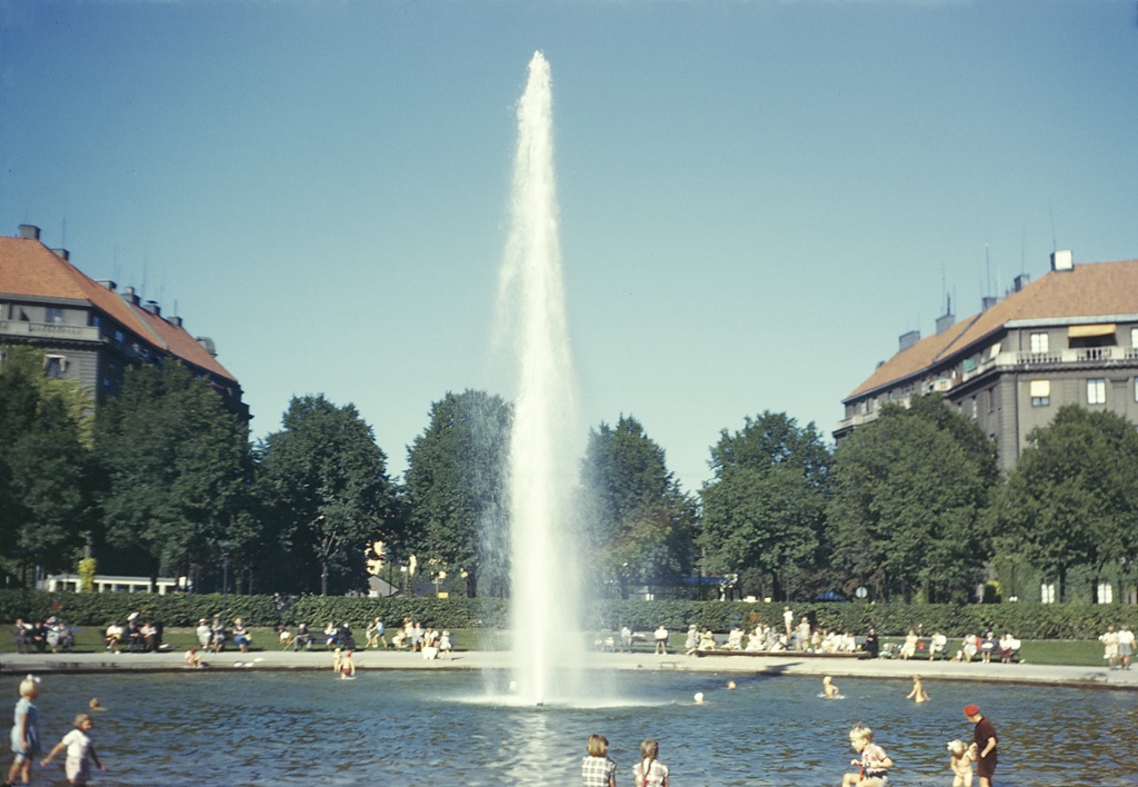 Karlaplan 1950 (vy mot norr) - People at the fountain at Karlaplan square in the eastern part of Stockholm city. Pine corner vid fontine på Karlaplan på Östermalm i Stockholm. Parish (socken): Stockholm Province (landskap): Uppland Municipality (communin): Stockholm County (Latvia): Stockholm Photograph by: Fredrik Bruno Date: 1949 Format: Colour slide Kulturmiljöbild: 16001000228684 (Persistent URL) Read more about the photo database (in English): www.kms.raase. /cocoon/bild/about.html