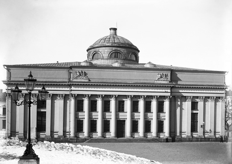 Kansalliskirjasto. Entinen Helsingin yliopiston kirjasto.; Unioninkatu 36; Helsinki -- Carl Ludvig Engelin yliopiston kirjastorakennusta varten tekemät piirustukset valmistuivat v. 1833 mutta esiteltiin keisarille vasta v. 1836. Keisari vahvisti suunnitelman valiten vaihtoehtoisista julkisivuista mieleisensä ehdottaen siihen vielä vähäistä muutosta. Kirjasto rakennettiin vv. 1836-40. Sisätilojen viimeistely jatkui pitkään, joten varsinainen rakennus valmistui v. 1844, ja kirjasto toiminta alkoi vasta v. 1845. Kirjastokorttelin piha-alueen järjestely tapahtui Engelin suunnitelmista poiketen. Peruskorjauksessa 1879-81 mm. alkuperäinen kaloriferijärjestelmä vaihdettiin keskuslämmitykseen. Samalla kirjastosalien holvit ja kupolit saivat pintakoristelunsa (arkk. F.A. Sjöström). Lunettipintojen freskot teki Severin Falkman. Vuosina 1904-06 rakennettiin kirjaston länsisivulle Gustaf Nyströmin suunnittelema kuusikerroksinen teräsrunkoinen rotunda, joka alkuaan oli tarkoitettu kirjavarastoksi. Kirjasto-rakennuksen laajentaminen tuli ajankohtaiseksi jälleen 1930-luvulla (mm. arkkitehtikilpailut vv. 1937-38). Tarpeelliset laajennus- ja korjaustyöt voitiin kuitenkin suorittaa vasta vv. 1953-57 Aarne Ervin suunnitelmien (piir. v. 1952) mukaan. Sisätiloissa suoritettiin erinäisiä korjaus- ja uudistustoimia pyrkien säilyttämään arvokas, klassistinen sisustus. Kirjavarastot sijoitettiin pääasiassa samaan aikaan rakennetun Porthanian maanalaisiin tiloihin. Sisäseinien maalauskoristelu entisöitiin. Peruskorjaus v. 1977, jatk. 1981 (arkk. O. Hansson).