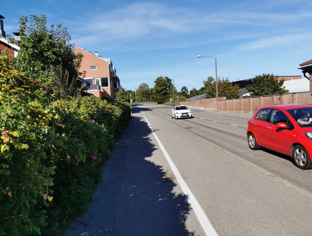 Itäistä Viertotietä (nykyisin Hämeentie) Vanhan kaupungin (nyk. Vanhakaupunki) eteläosien kohdilla. Oikealla takana nykyisen Koskipuiston alue. Helsingin Muinaismuistolautakunta  ja valokuvaaja Signe Brander "sunnuntairetkellä" katsastamassa kuvauskohteita Vanhassakaupungissa Itäisellä Viertotiellä (Hämeentie 166, 165). rephoto