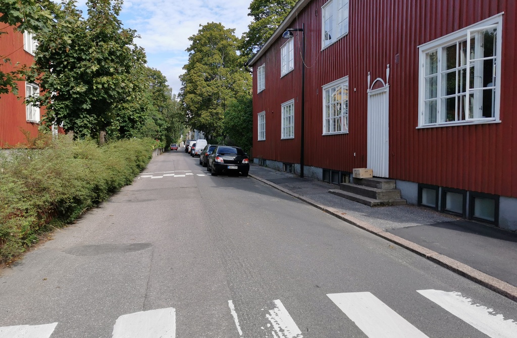 Limingantie 9. Katunäkymä Limingantieltä Jyrängöntien kulmasta koilliseen kevätauringon sulattaessa lumia. Oikealla olevissa kaksikerroksisissa puutaloissa myymälöitä, edessä Limingantie 9:ssä H.M. Laineen K-kauppa. rephoto