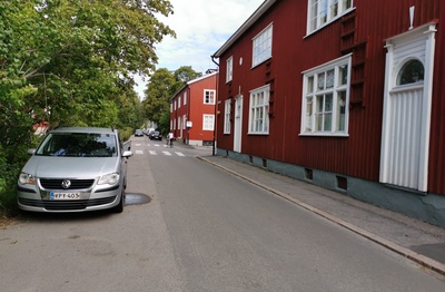 Limingantie 9. Katunäkymä Limingantieltä Jyrängöntien kulmasta koilliseen kevätauringon sulattaessa lumia. Oikealla olevissa kaksikerroksisissa puutaloissa myymälöitä, edessä Limingantie 9:ssä H.M. Laineen K-kauppa. rephoto