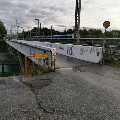 Helsinginkadun alikäytävä, juna tulossa keskustasta, takana Töölönlahti. rephoto