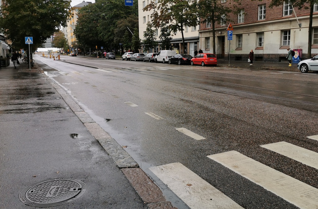 Kolme poikaa katselemassa Helsinginkatu 9:n eteen parkkeerattua autoa (neliovinen Ford sedan, vm. 1951). Taustalla Harjutori sekä Helsinginkatu 6, 10. rephoto