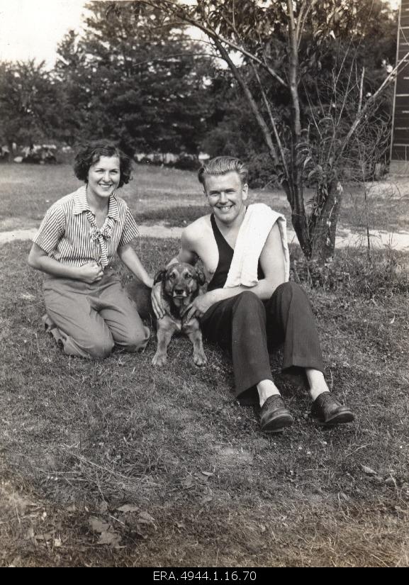 Ernst Jaakson and Claire Langenbacher with a dog in the garden.