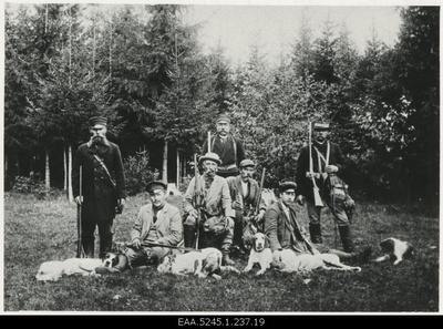 Hunting company near the forest posing with its guns and dogs  duplicate photo