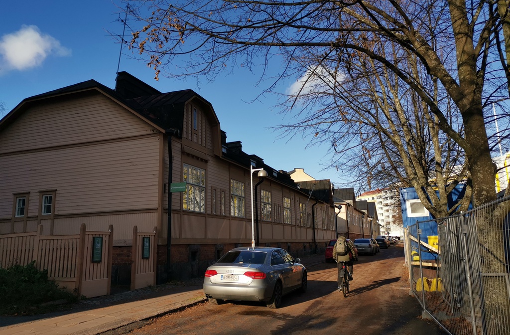 Näkymä pitkin Kirstinkujaa kohti Porvoonkatua, Kirstinkuja 4, 6, Vesilinnankatu 17 sekä äärimmäisenä oikealla Porvoonkatu 19. Kadun varrelle on pysäköity henkilöautoja ja koottu korkea lumikinos. rephoto