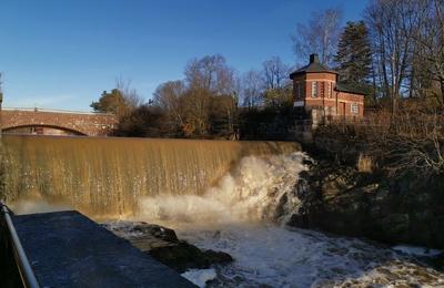 Vanhankaupunginkoski jäidenlähdön aikaan. Taustalla maantiesilta, oikealla vesilaitoksen rakennuksia. rephoto