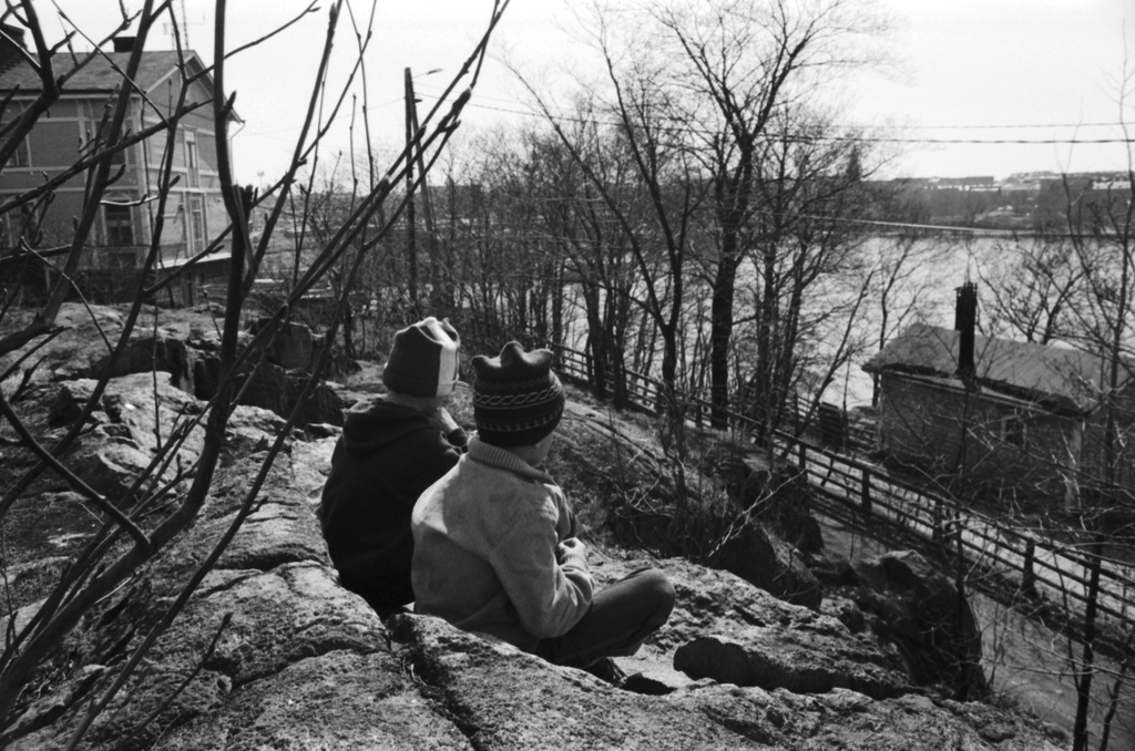 Linnunlauluntie. Näkymä pääradan varresta Linnunlaulun keväisiltä kallioilta etelään Töölönlahden suuntaan. Kaksi poikaa (Tuomas Heikkilä ja Aapo Rista) istumassa kalliolla. Vasemmalla Linnunlauluntie 12:n talo.