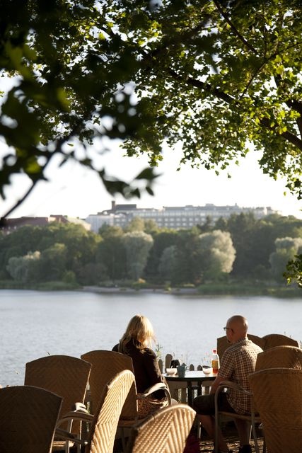 Blue Huvila Café, garden area; outlook, customers at the table, behind Töölönlahti