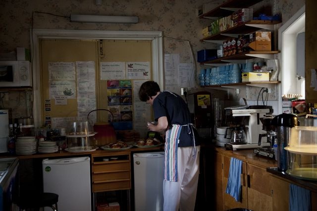 Blue Huvila Cafe, kitchen; interior picture, employee prepares a sales table before opening