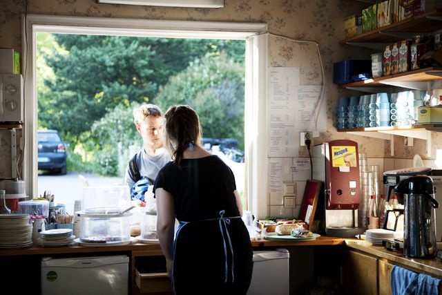 Blue Huvila Cafe, kitchen; interior picture, employee serves the customer, view from the kitchen