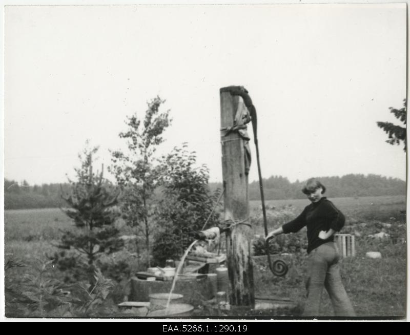 Young woman pumping water pumping pump
