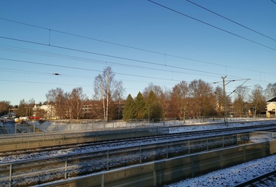 Oulunkylä, näkymä rautatieaseman raiteilta luoteeseen, kohti Kottbyn tilaa. Peltojen takana vasemmalla tilan navetta ja keskellä päärakennus (Teinintie 25). Taustalla oikealla Oulunkylän vanha kirkko (Siltavoudintie 12). rephoto