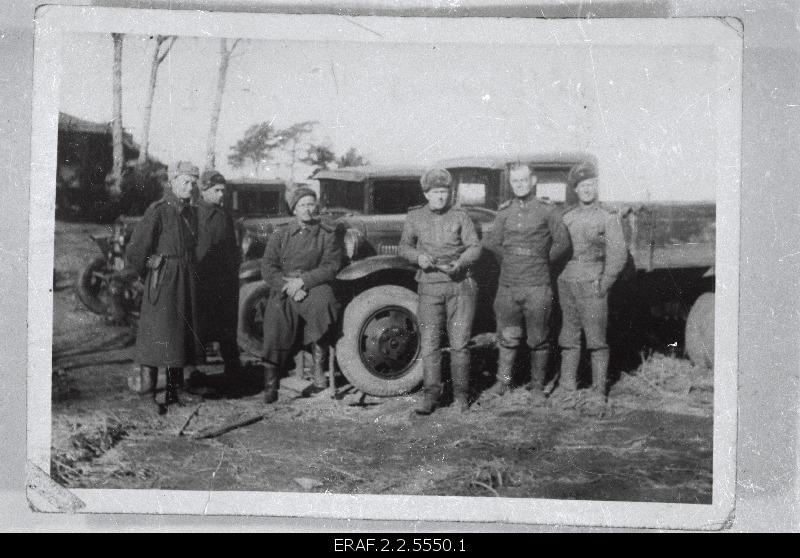 The fighters of the army parts of the Estonian Laskurkorpus are posing at trucks.