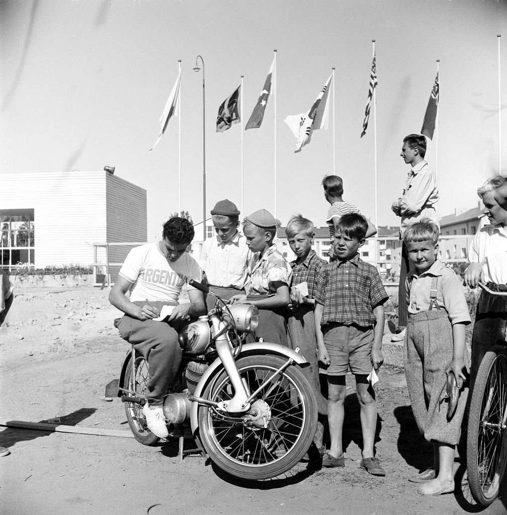 Helsingin olympialaiset 1952. Argentiinalainen urheilija jakaa nimikirjoituksia lapsille saksalaisen NSU Fox -moottoripyörän selässä Käpylän kisakylän edustalla.