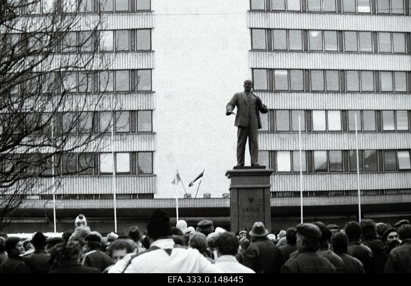 Marching of the 73th anniversary of the October Revolution V.I. At the memorial pillar of Lenin. In the back of the central committee building with a blue-black-white and red flag.
