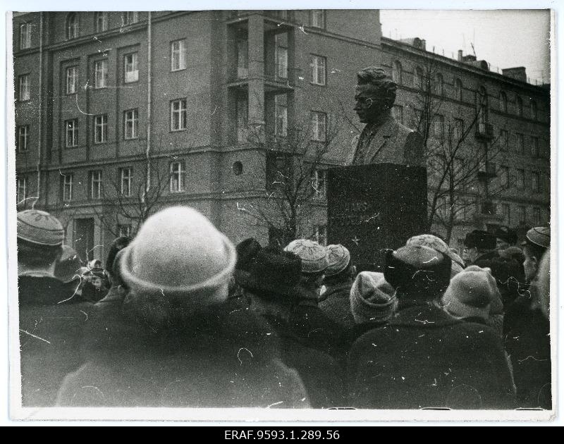 Photo of the heads of people gathered to the monument pillar.