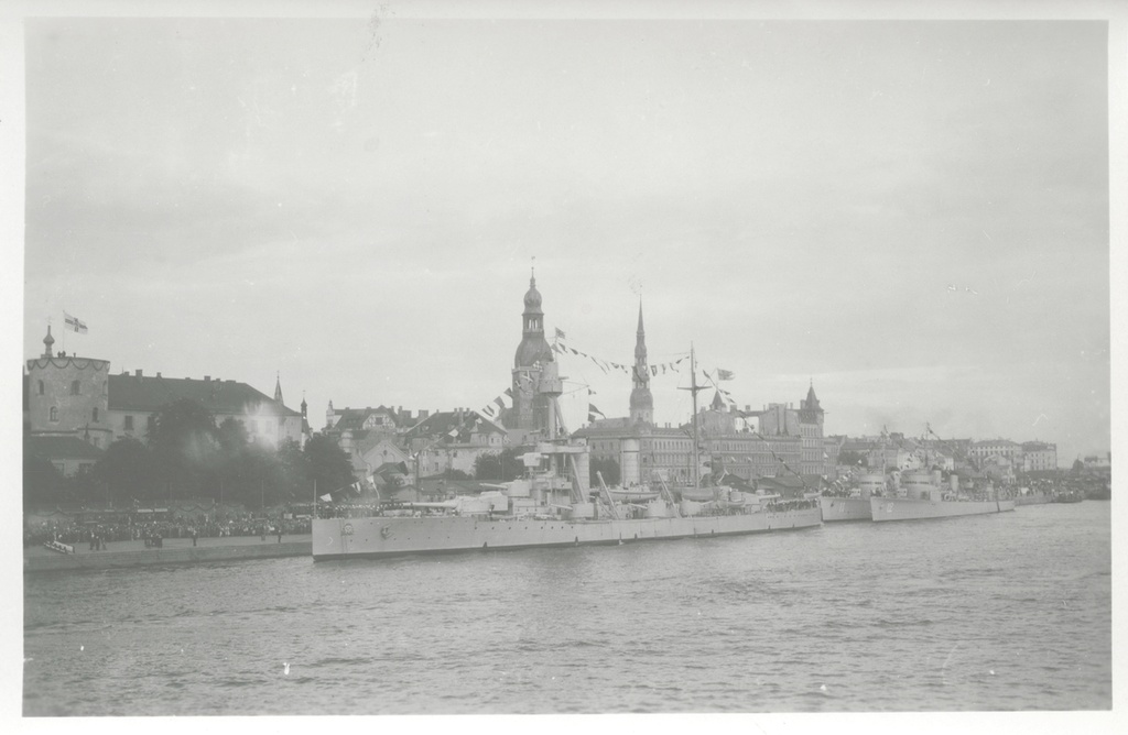 Pansarskeppet Drottning Victoria with jagarna EHRENSKÖLD och Nordenskjöld vid kaj i Riga. På kajkanten en thick folksamling. Form har uppenbarligen tagits i samband med Gustaf V statsbesök i Riga i juni 1929. It embroidery Fo229138 och Fo229417A.