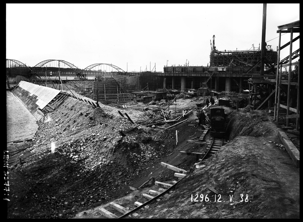 Daugavas labā krasta zemes dambja un ūdens ieteču joslas izbūve augšpus Ķeguma spēkstacijas ēkas. 1938.gada 12.maijs - From 1936 until 1940, the remarkable Latvian cameraman and photographer E. Kraucs (1898 – 1977) regularly, 1 – 2 times a week, photographically documented the construction of the Kegums power plant.