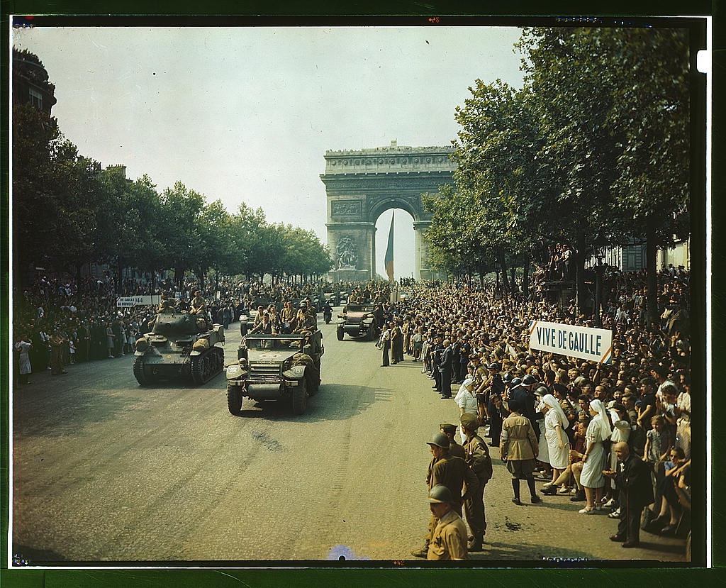 Crowds of French patriots line the Champs Elysees to view Allied tanks and half tracks pass through the Arc du Triomphe, after Paris was liberated on August 25, 1944 (Loc)