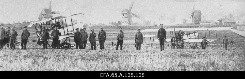 Two planes at the Farman airport, three windmills back there.