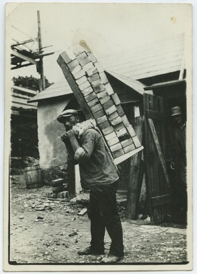A worker wearing bricks with "single".  duplicate photo