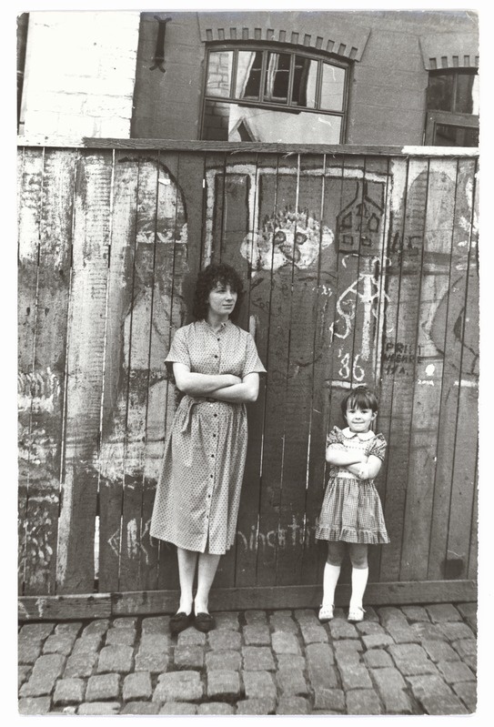 Woman and girl with paintings in the background of the plank on the neck of Old Market 10