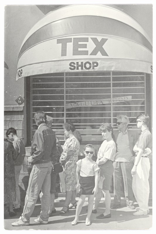 A girl with daykeepers in front of the currency store, in order.