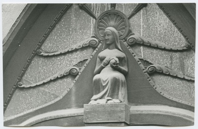 Wood-made form of a sitting woman at the door of the 26th house of the Wallvahe Street.  duplicate photo