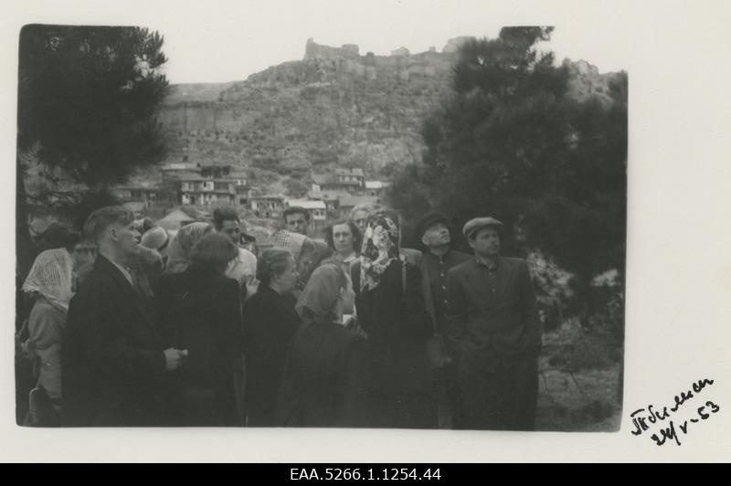 B. Good tourist trip in Caucasus. Group of tourists in Tbilisi on the Komsomoli alleel, on the back of the mountains the ruins of the fortress