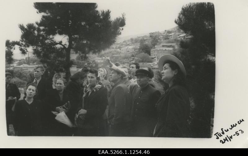 B. Good tourist trip in Caucasus. Group of tourists in Tbilisi on the Komsomoli alley, in the backyard of the hills of the city buildings